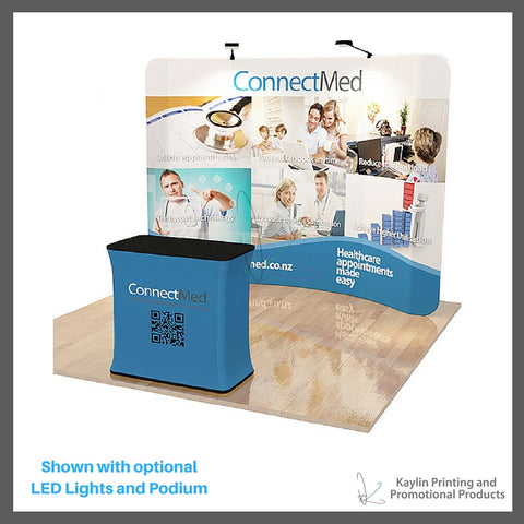 KYN-TSD-001 Tradeshow Display with 10 foot curve shape and vibrant graphics printed on fabric. Personalized with your custom imprint or logo. Shown with optional LED Lights and Podium.